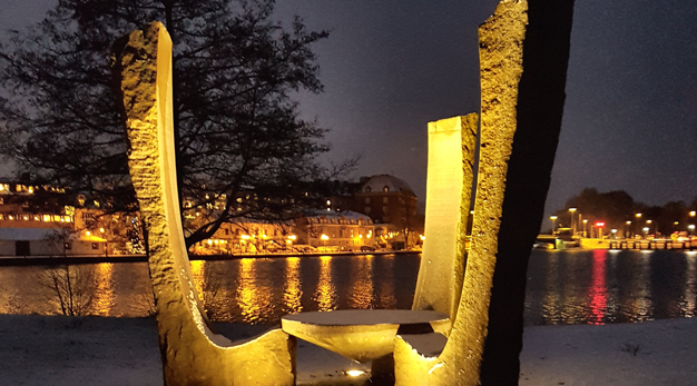 Stenskulptur format som tre stora stolar runt ett bord.
