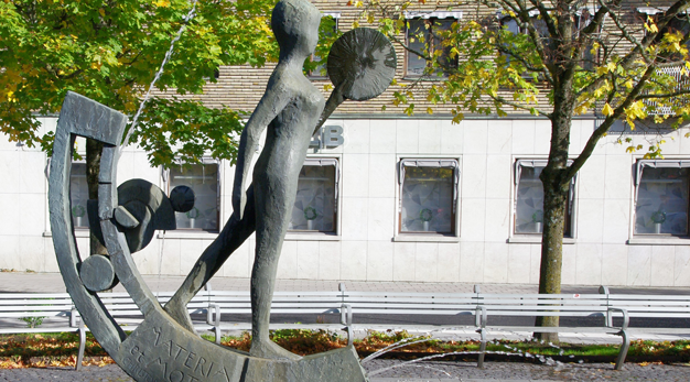 En stenskulptur av en människogestalt placerad i en fontän. 