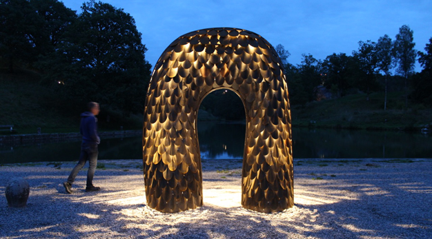 Portal eller båge i cortenstål format som fiskfjäll som lyser innifrån