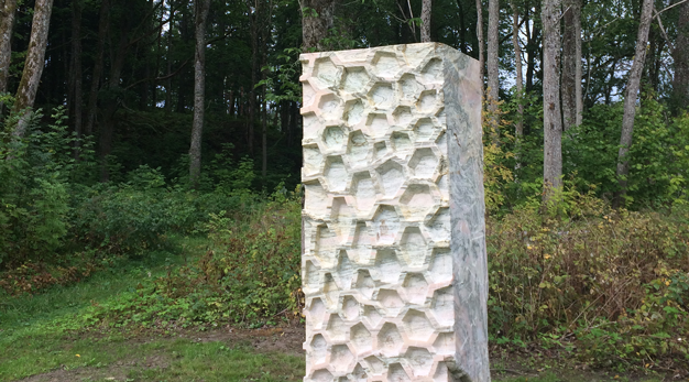 Rektangulär, stående skulptur i ljus marmor.