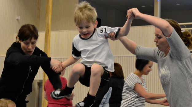 Hoppande pojk i gymnastiksal