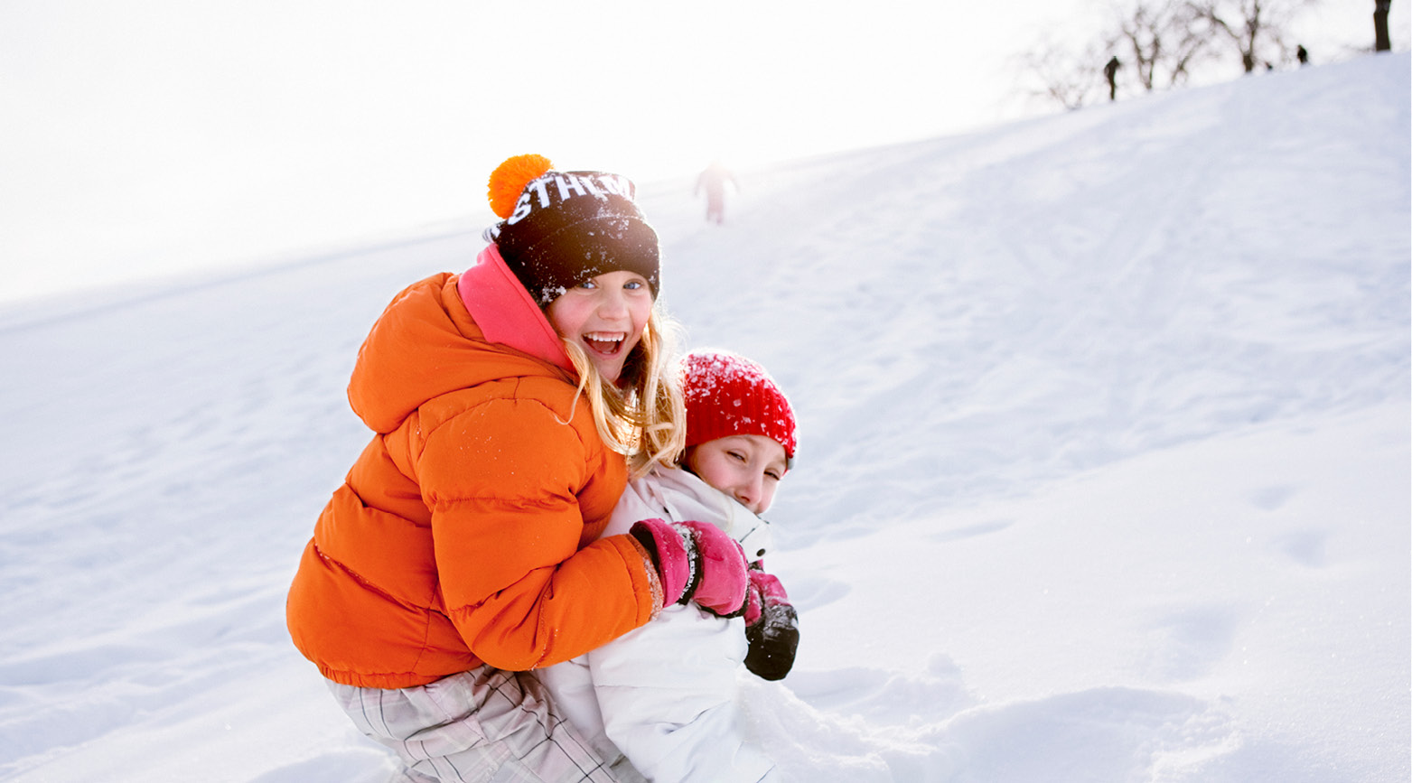 Barn som åker stjärnlapp i pulkabacke.