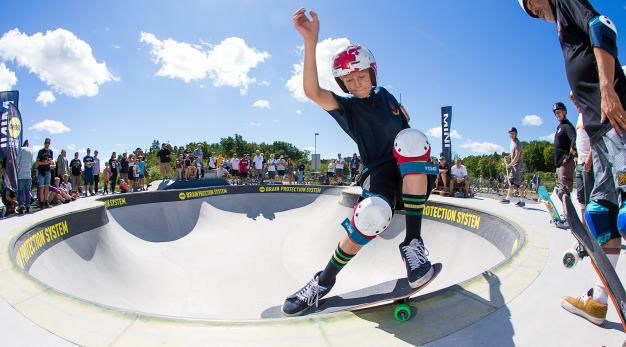 Ung kille som åker skatebord i en skatebordpark