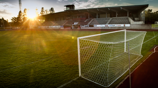 Fotbollsplan i ljuset av solnedgången. 