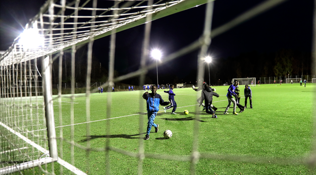 Pojkar spelar spontanfotboll på konstgräsplan.