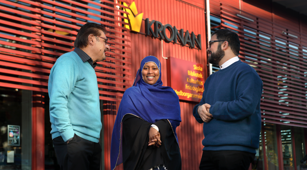 Tre personer står och samtalar.
