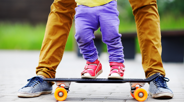 Ett litet barn står på en skateboard