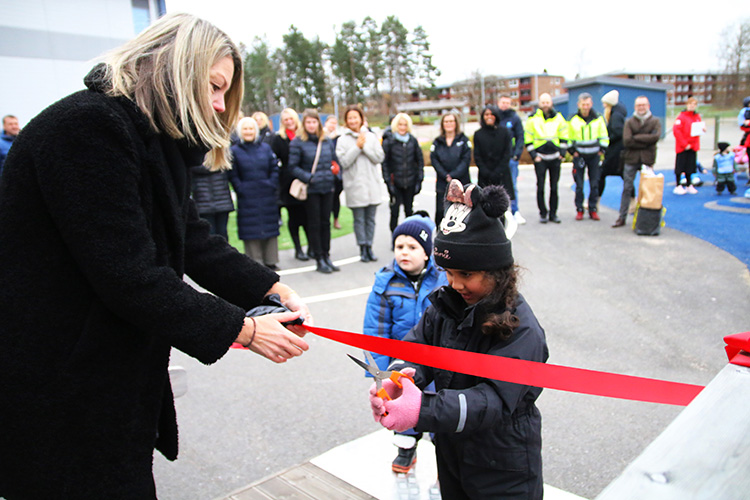 Rektor Malin Björnman klipper band med ett av barnen på förskolan