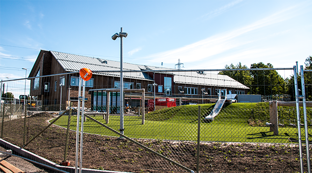 Utemiljö med skolbybyggnad i bakgrunden