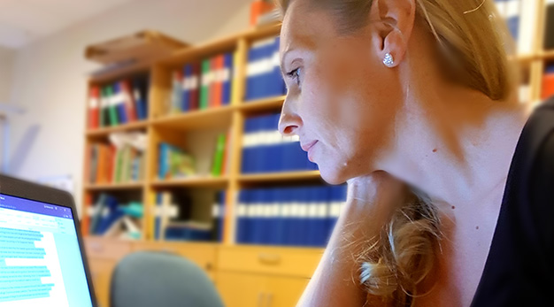Lärare sitter framför dator