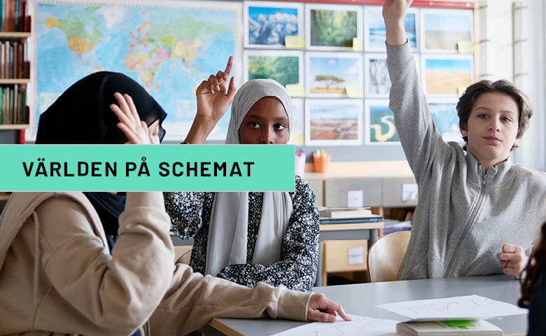 Elever som räcker upp handen i klassrummet med världskarta i bakgrunden. 