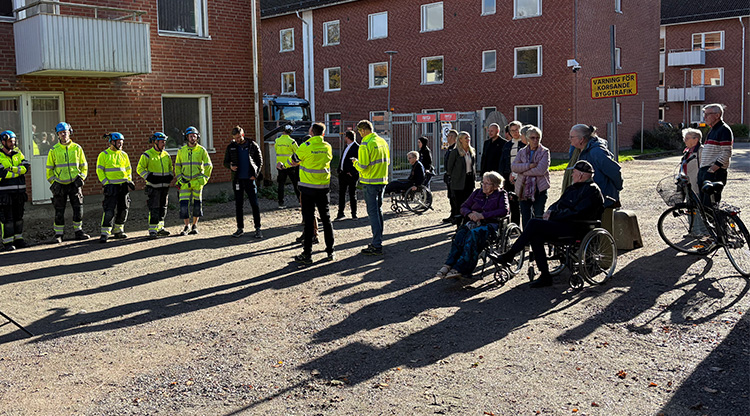 Människor som väntar på att få gå in i en ny byggnad