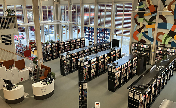 Kronan biblioteks lokaler med stora fönster och många fyllda bokhyllor.