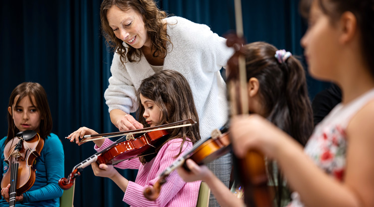 Pedagog undervisar elev i fiol